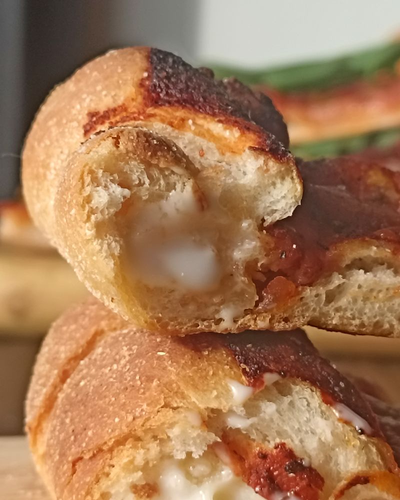 Corte del borde de una Pizzalvi, con el queso blanco y cremoso por dentro de la masa