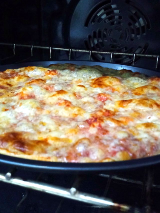 Una Pizzalvi dentro del horno, con el queso burbujeando y dorándose